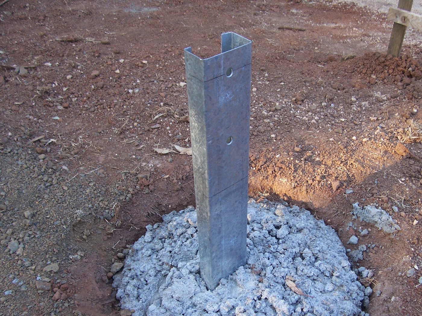 Galvanised steel stump set into a concrete footing